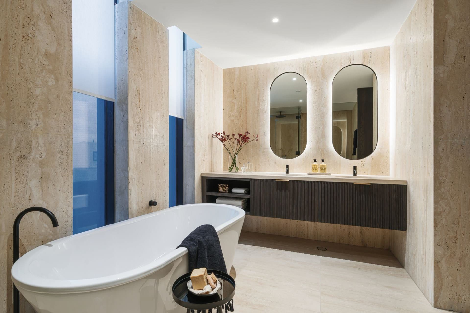 Ensuite with freestanding bath, twin arched mirrors and travertine