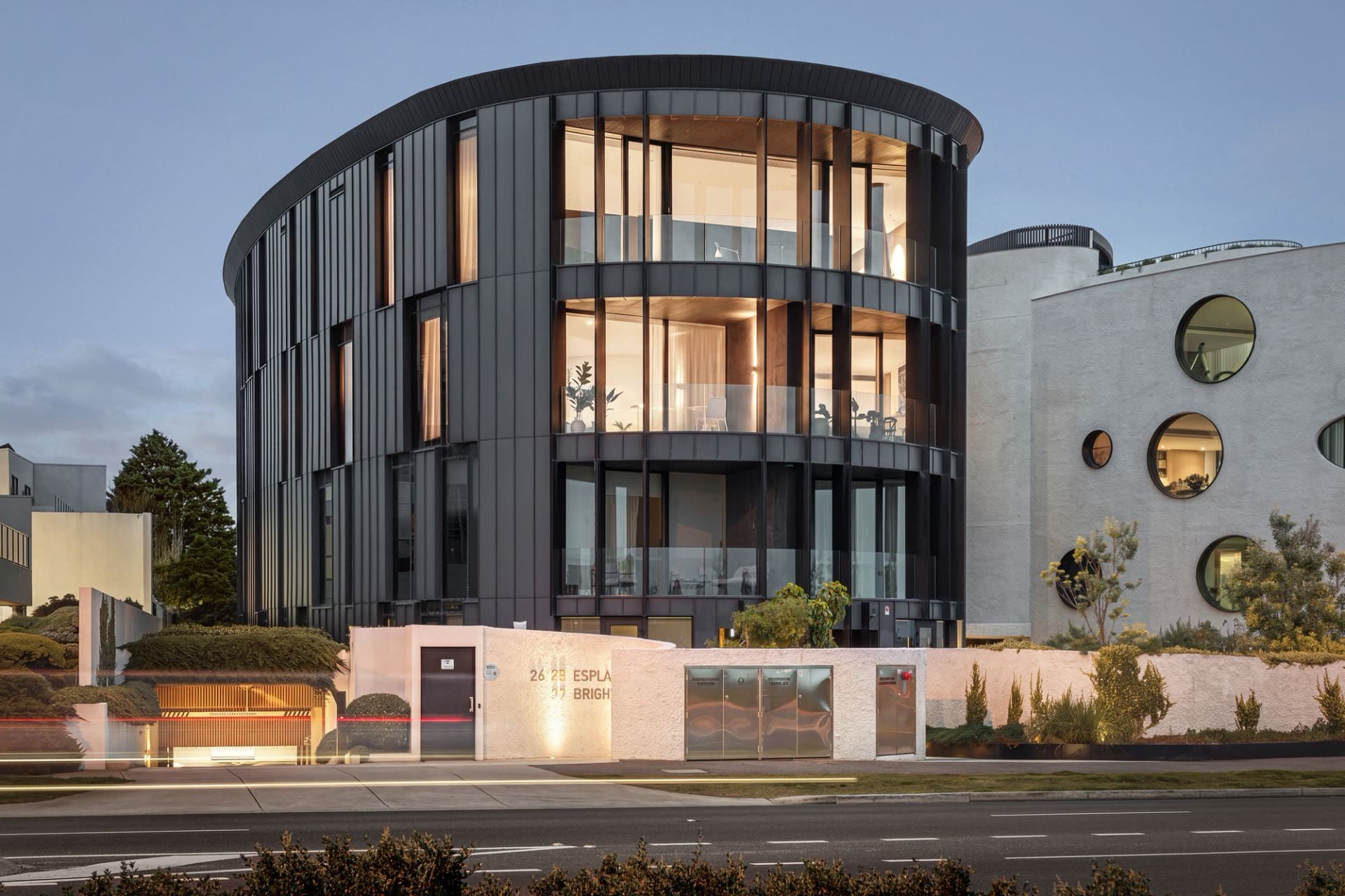 The dark curved Wood Marsh building at dusk, seen from the Esplanade